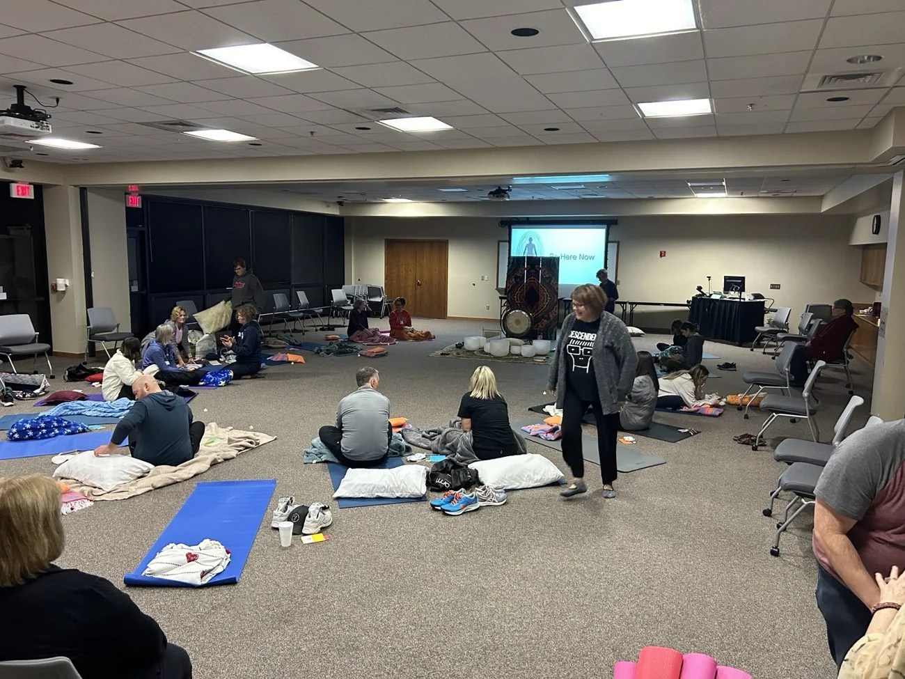 Participants settling onto mats in a group sound bath