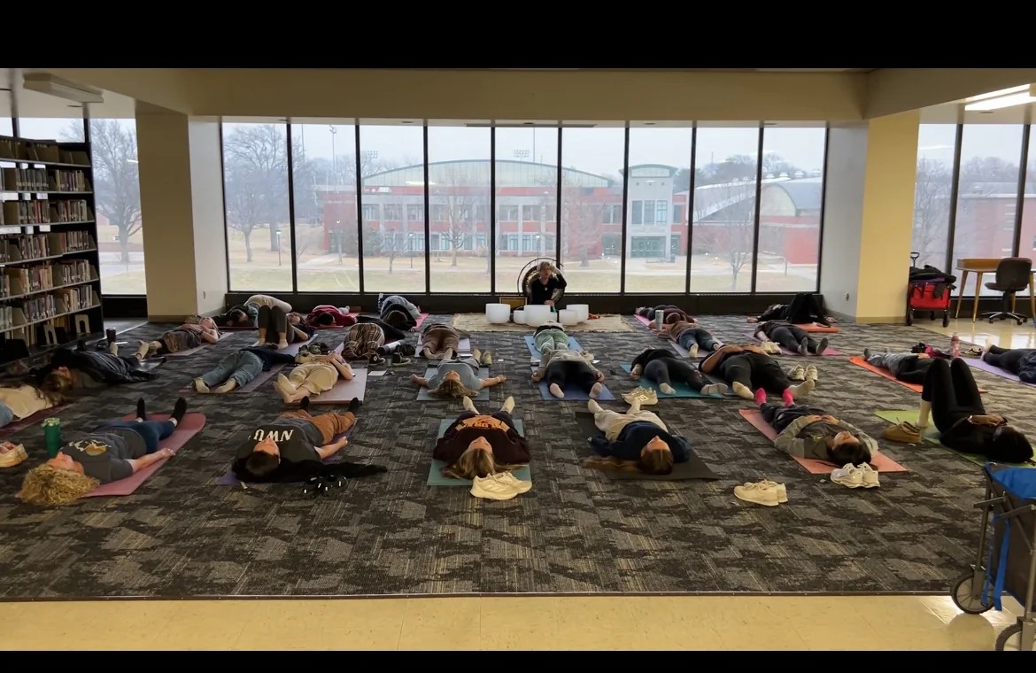 Participants resting on mats during an Accord Soundworks session at Cochrane-Woods Library, Nebraska Wesleyan University